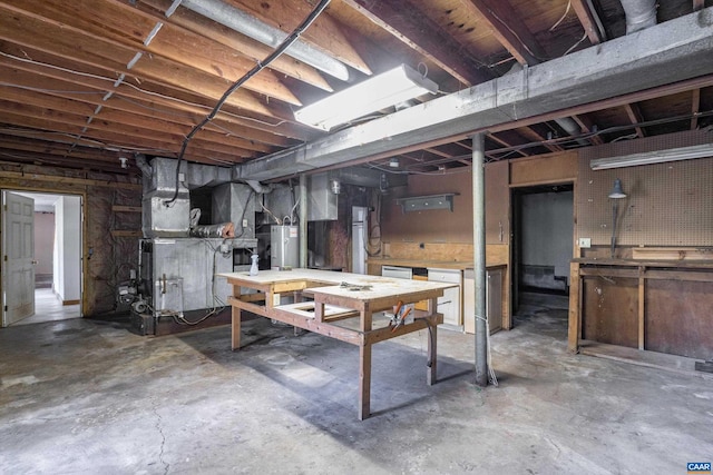 basement featuring water heater, heating unit, and a workshop area