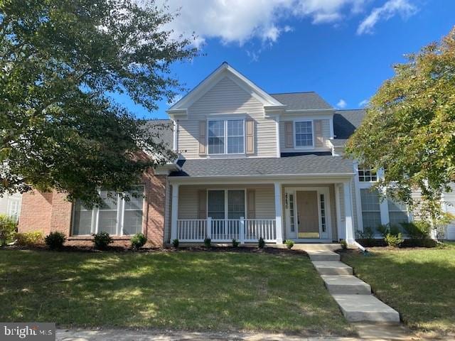 view of front of home with covered porch and a front lawn