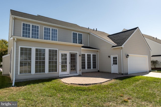 rear view of house featuring a garage, a yard, and a patio