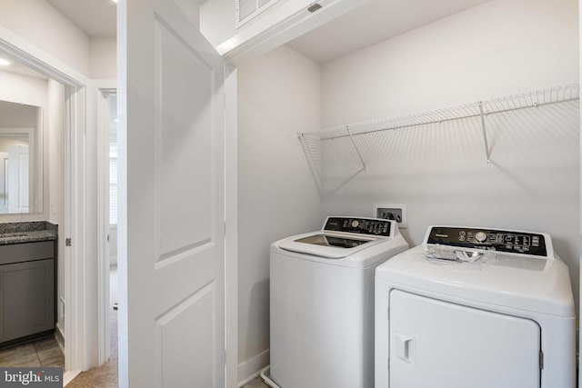 clothes washing area with light tile patterned flooring and independent washer and dryer