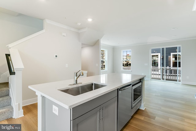 kitchen with gray cabinets, a center island with sink, light wood-type flooring, and sink