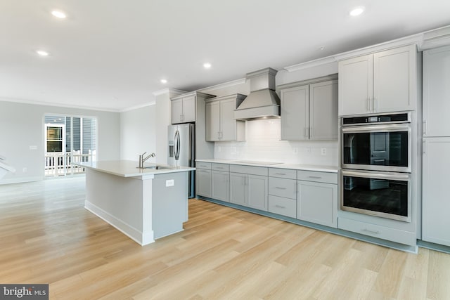 kitchen featuring custom range hood, light hardwood / wood-style floors, and stainless steel appliances