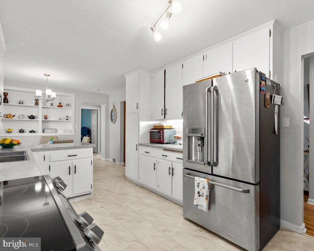 kitchen with white cabinets, hanging light fixtures, and stainless steel appliances