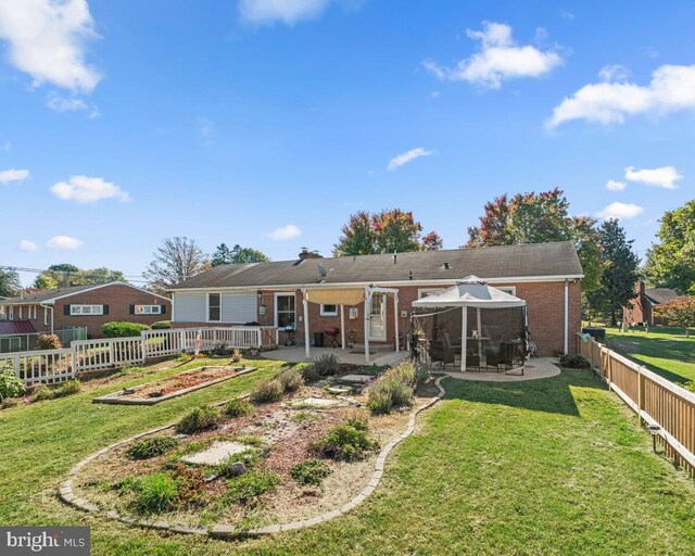 back of property featuring a patio area and a yard