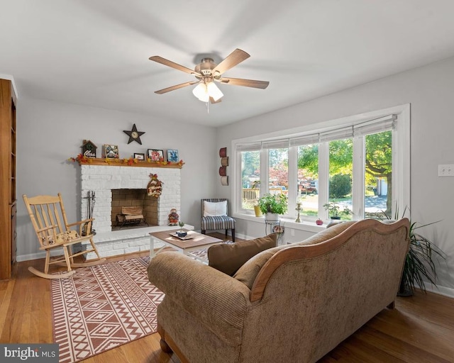 living room with ceiling fan, a fireplace, and hardwood / wood-style floors