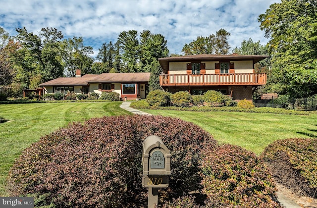 view of front facade featuring a front yard and a balcony