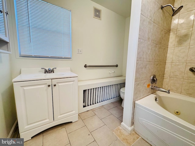 full bathroom featuring tiled shower / bath, tile patterned floors, vanity, and toilet