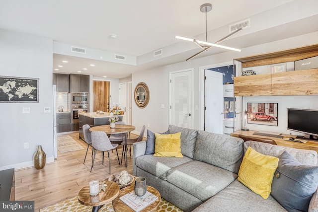 living room with a chandelier and light hardwood / wood-style flooring