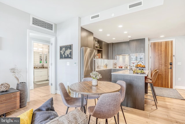 dining space featuring sink and light hardwood / wood-style flooring