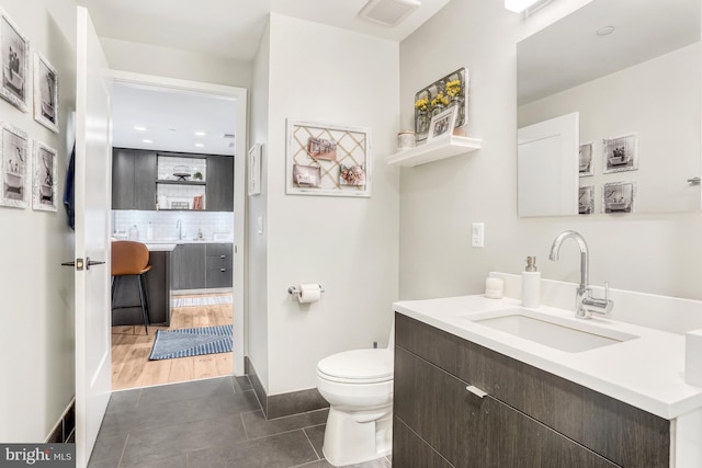 bathroom featuring vanity, tile patterned flooring, toilet, and decorative backsplash