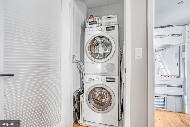 laundry area featuring stacked washer / dryer and light wood-type flooring