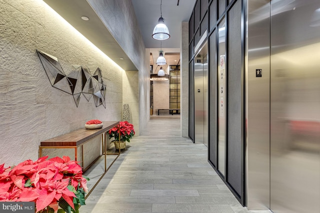 hall featuring elevator and light hardwood / wood-style flooring