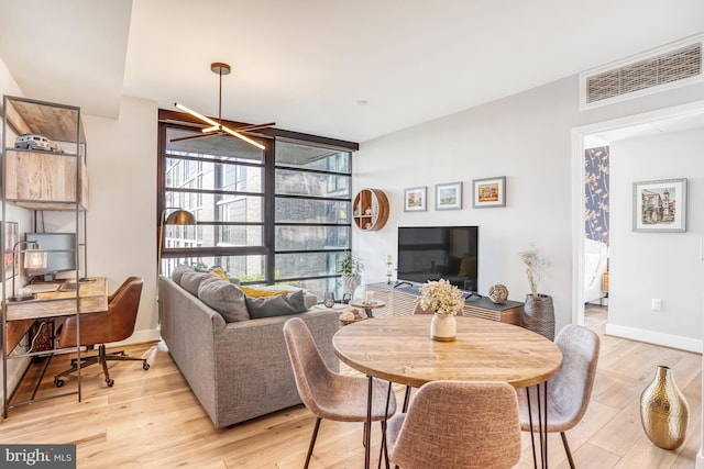 dining room featuring light hardwood / wood-style flooring and an inviting chandelier