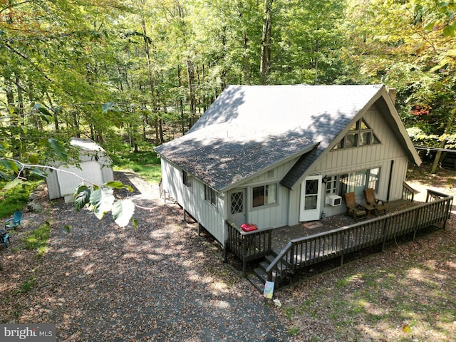 exterior space featuring a garage, an outbuilding, and a deck