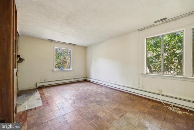 empty room with a textured ceiling and baseboard heating