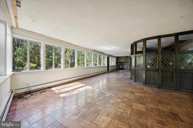 unfurnished sunroom featuring a baseboard heating unit