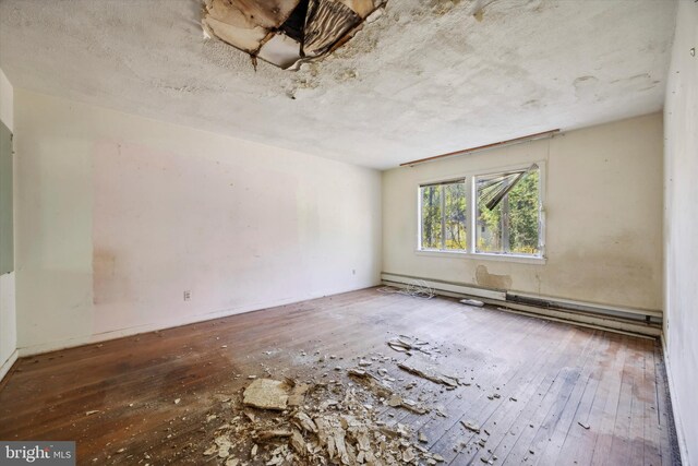 spare room with hardwood / wood-style flooring and baseboard heating