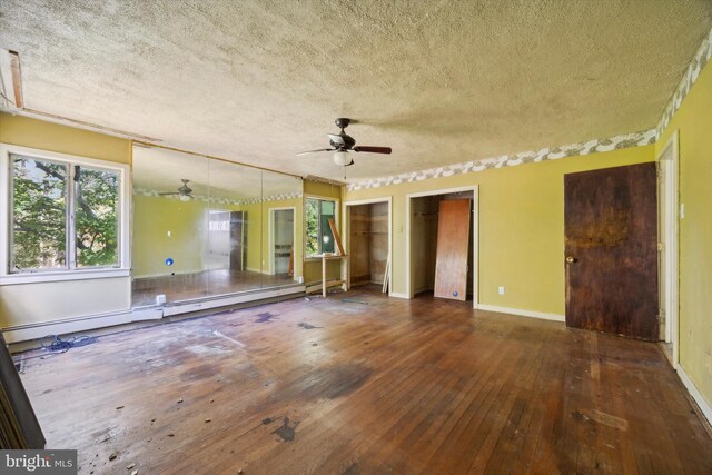 empty room with a baseboard radiator, a textured ceiling, dark hardwood / wood-style floors, and ceiling fan