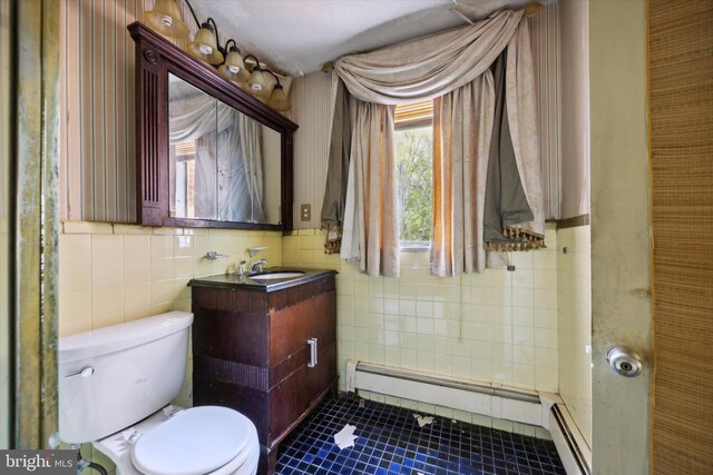 bathroom featuring vanity, toilet, tile walls, and a baseboard heating unit