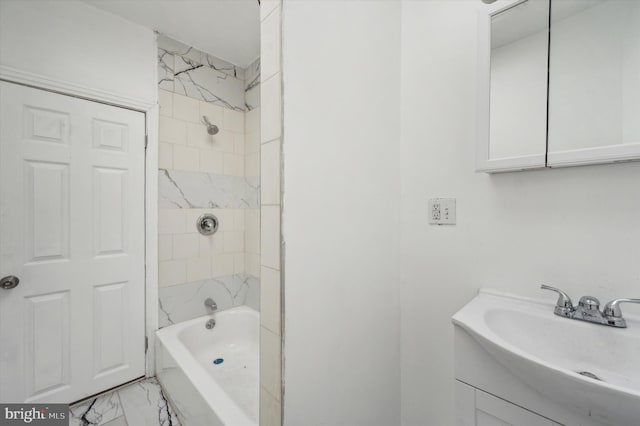 bathroom featuring tiled shower / bath and vanity