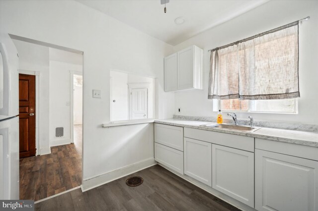 128 N Dewey St, Philadelphia, PA 19139 - kitchen with visible vents, white cabinets, a sink, light countertops, and dark wood-type flooring