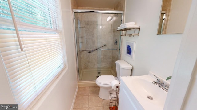 bathroom with vanity, toilet, walk in shower, tile patterned flooring, and a wealth of natural light