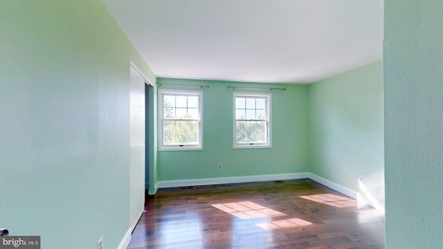 spare room with dark hardwood / wood-style floors