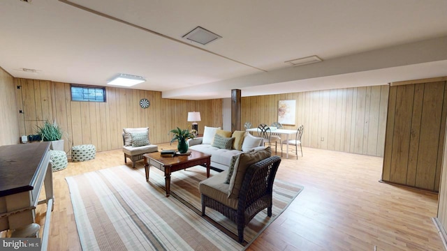 living room featuring wood walls and light hardwood / wood-style floors