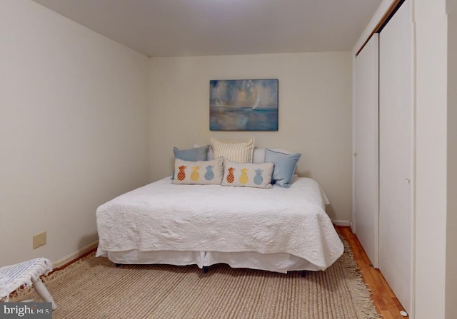 bedroom with a closet and light hardwood / wood-style flooring