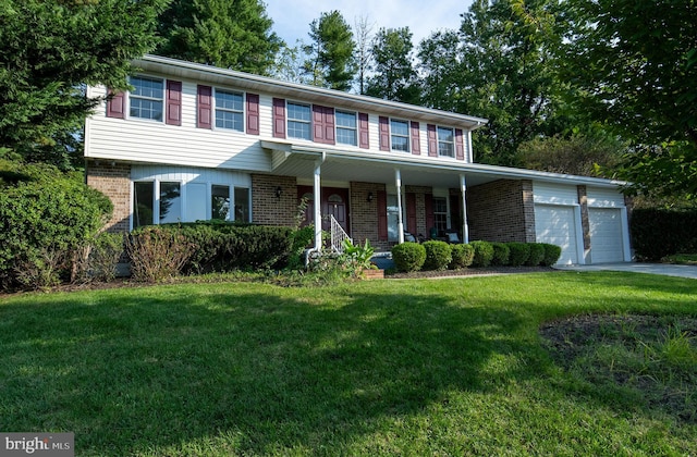 view of front of house with a garage, a front yard, and covered porch