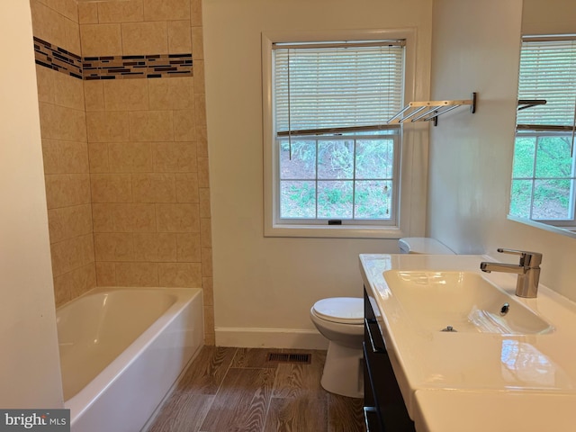 bathroom featuring visible vents, vanity, wood finished floors, toilet, and baseboards