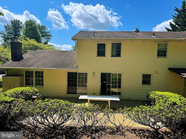 rear view of house featuring a chimney