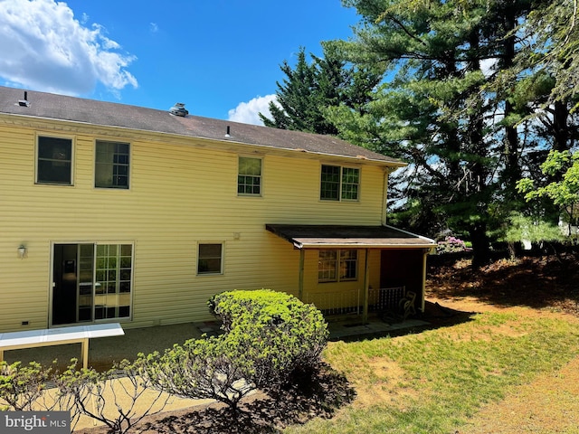 rear view of house featuring a yard