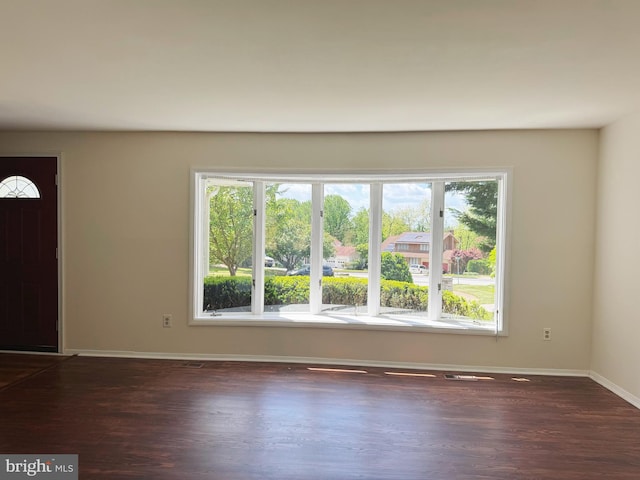 entrance foyer featuring baseboards and dark wood finished floors