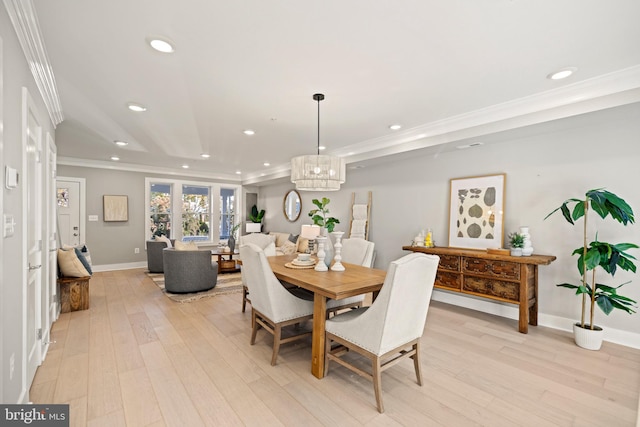 dining room with light hardwood / wood-style floors, an inviting chandelier, and ornamental molding