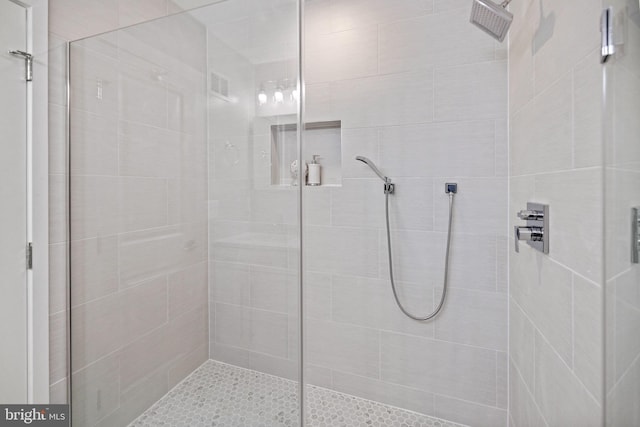 bathroom featuring a shower with door