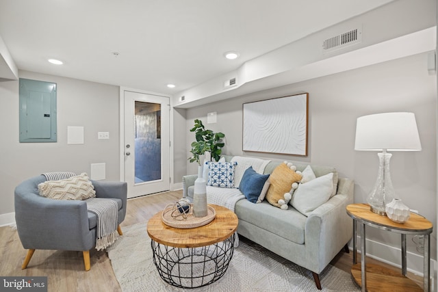 living room with light hardwood / wood-style floors and electric panel