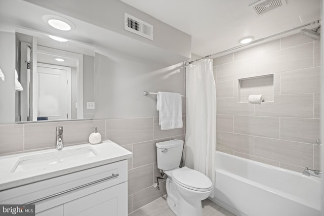 full bathroom featuring shower / bath combo, toilet, tile patterned floors, tile walls, and vanity