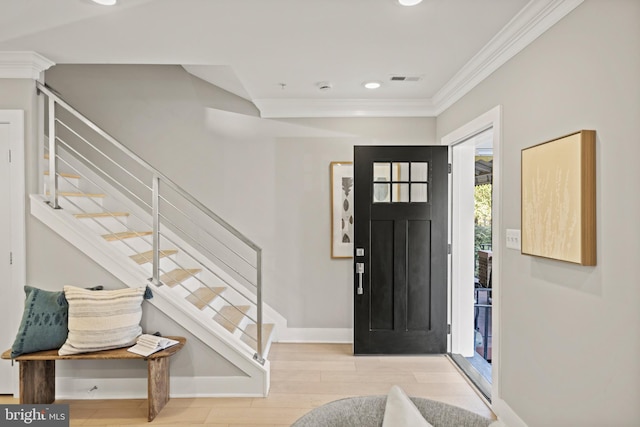 foyer entrance featuring light hardwood / wood-style floors and crown molding