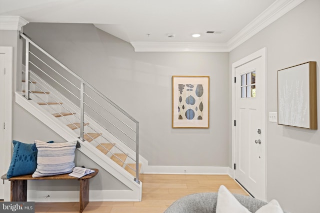 entrance foyer with ornamental molding and hardwood / wood-style flooring