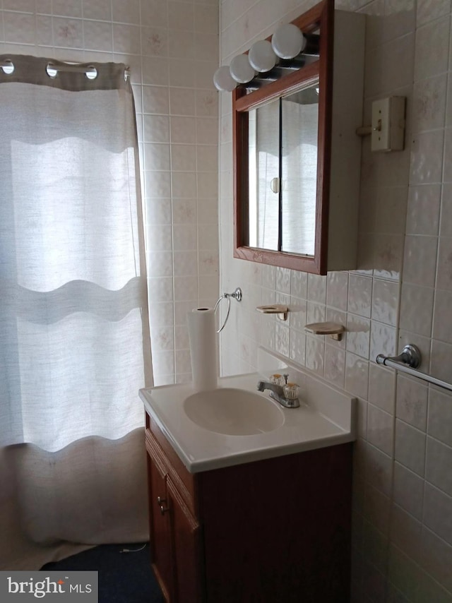 bathroom with vanity, decorative backsplash, and tile walls