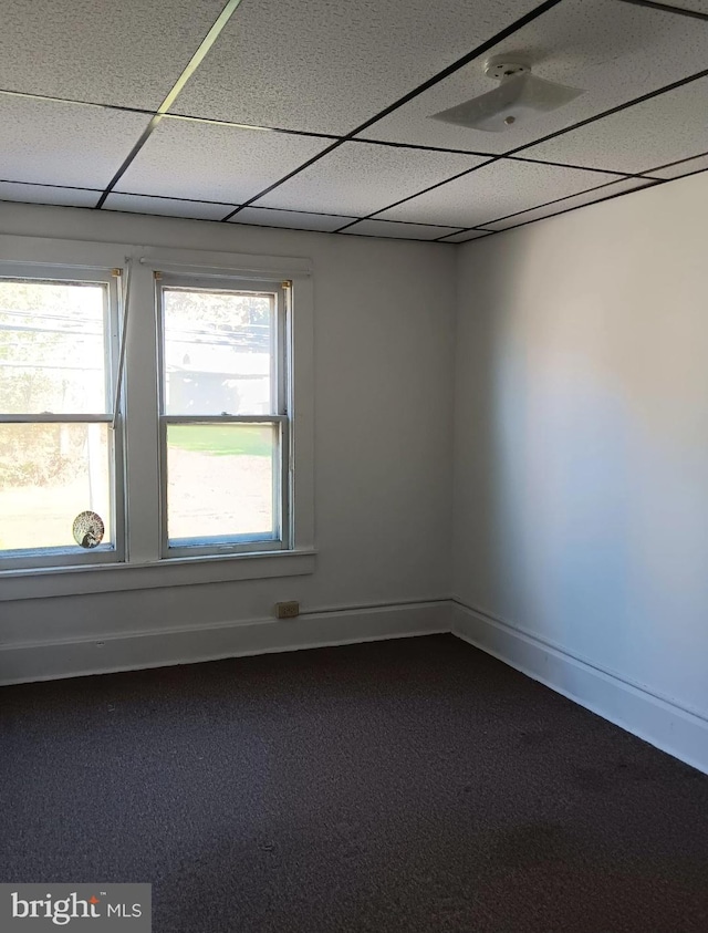 unfurnished room featuring a paneled ceiling and carpet floors