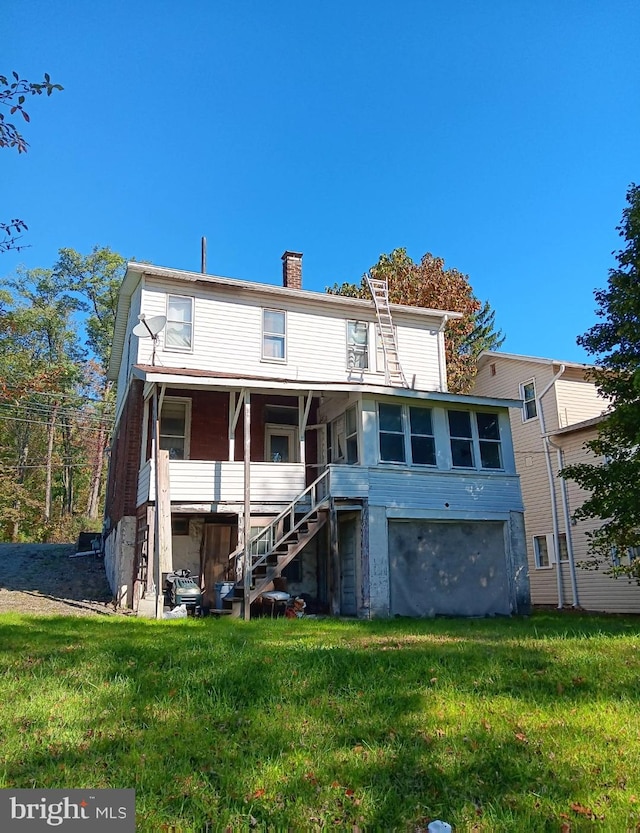 rear view of house featuring a yard