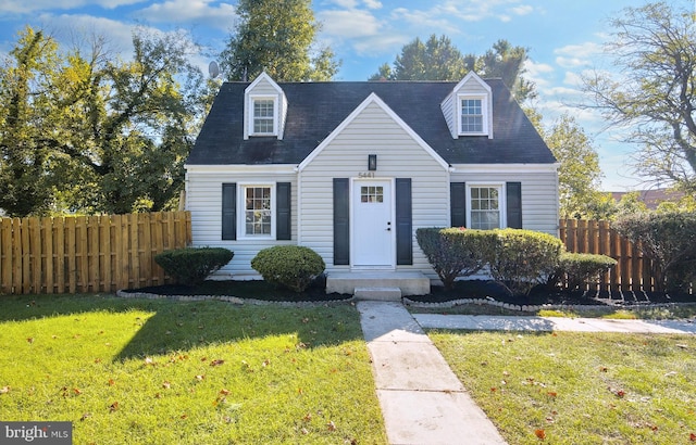 cape cod home with a front yard