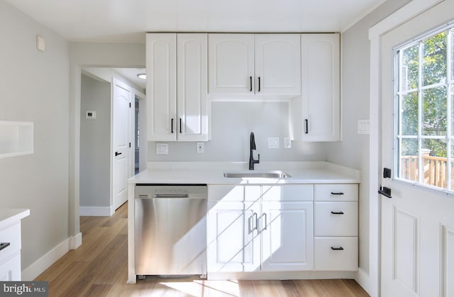 kitchen featuring white cabinets, light hardwood / wood-style floors, sink, and stainless steel dishwasher