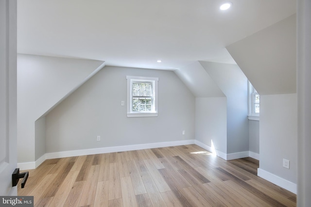 bonus room with lofted ceiling and light wood-type flooring