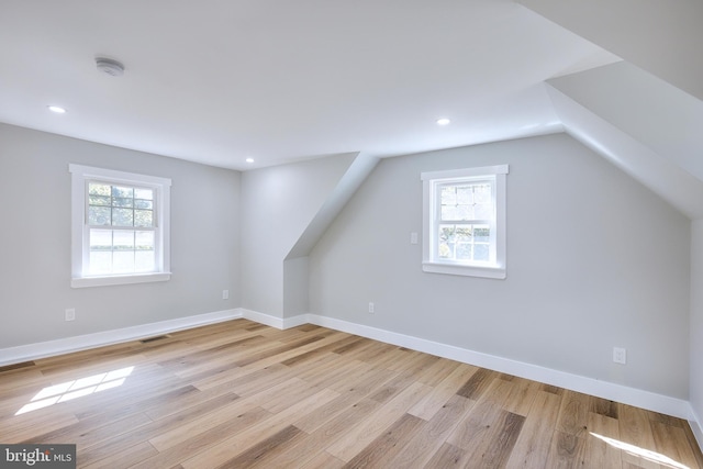 additional living space with plenty of natural light, light hardwood / wood-style floors, and vaulted ceiling