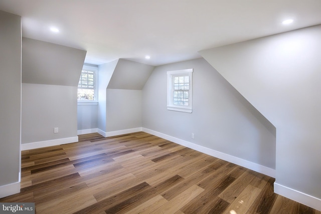 additional living space featuring hardwood / wood-style flooring and lofted ceiling