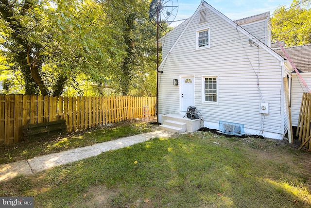 rear view of house featuring a lawn