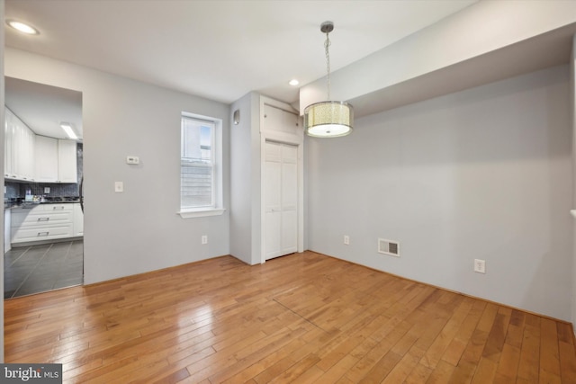 unfurnished dining area featuring wood-type flooring